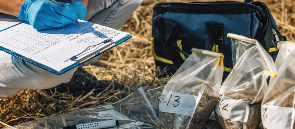 Soil Test. Female agronomist taking notes in the field. Environmental protection, organic soil certification, research